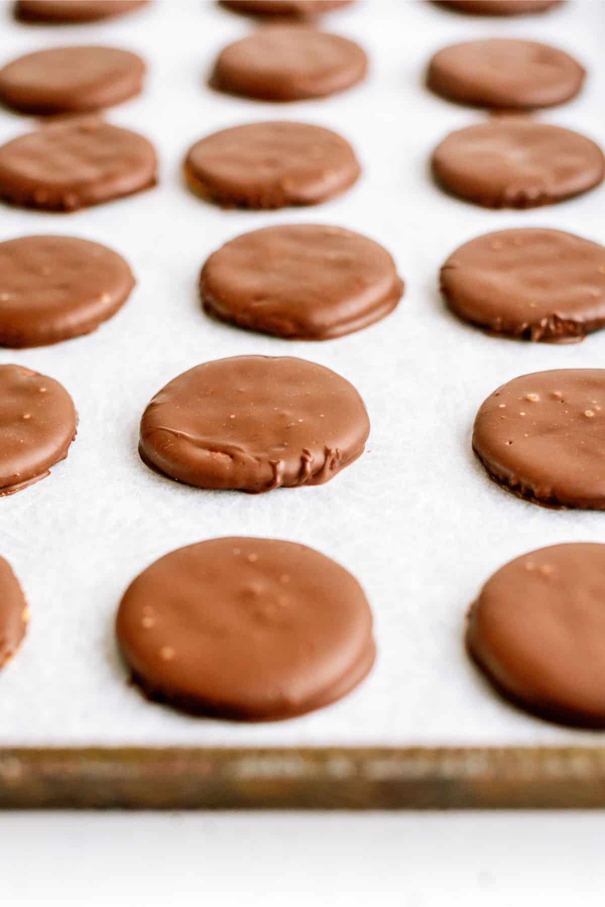 Dipped ritz crackers on a baking sheet lined with wax paper