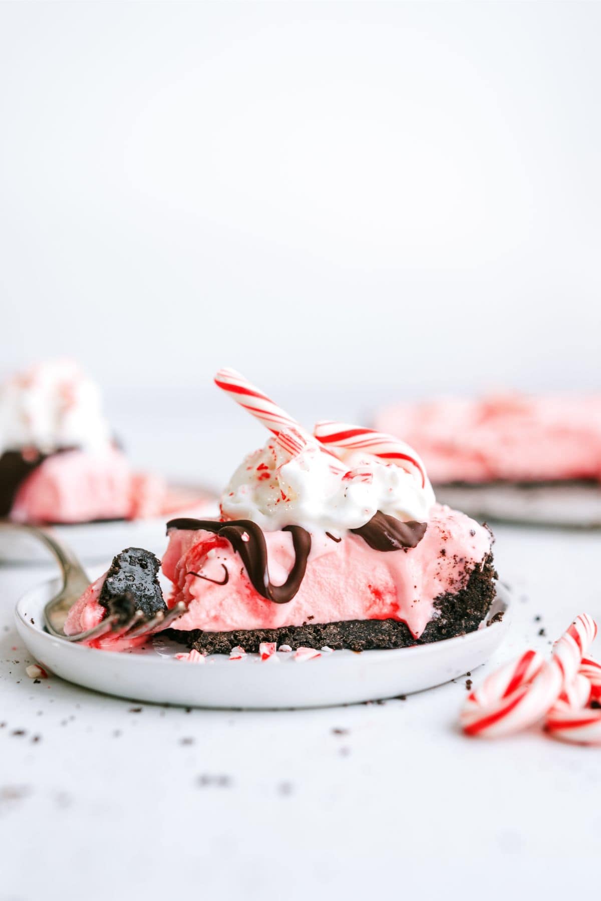 A slice of Peppermint Crunch Ice Cream Pie on a plate with a fork