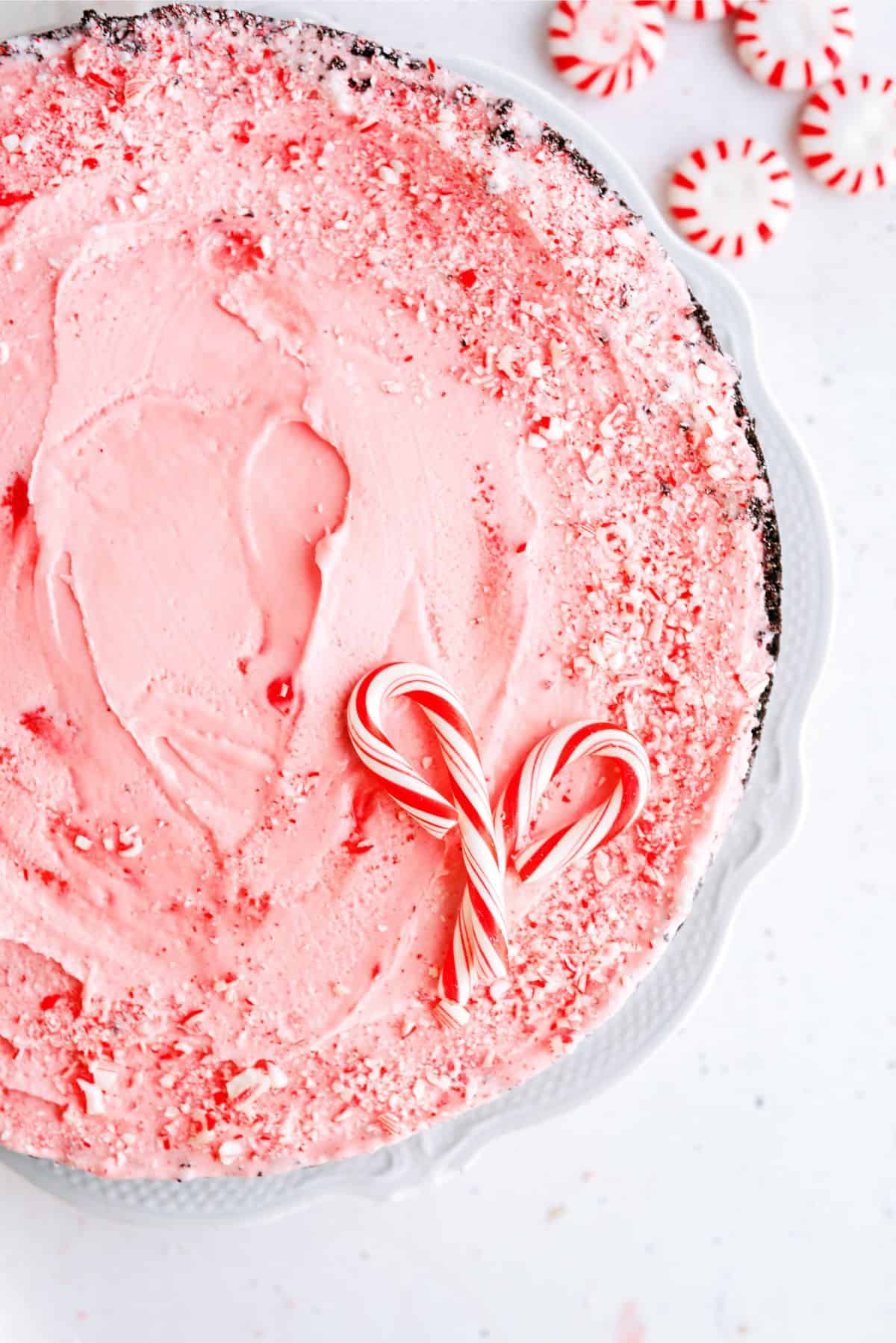 Top view of Peppermint Crunch Ice Cream Pie on a countertop with unwrapped peppermints.