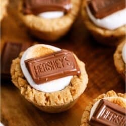 S’mores Cookie Cups sitting on a wooden cutting board.