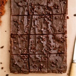 2 Ingredient Pumpkin Brownies cut into squares on parchment paper.