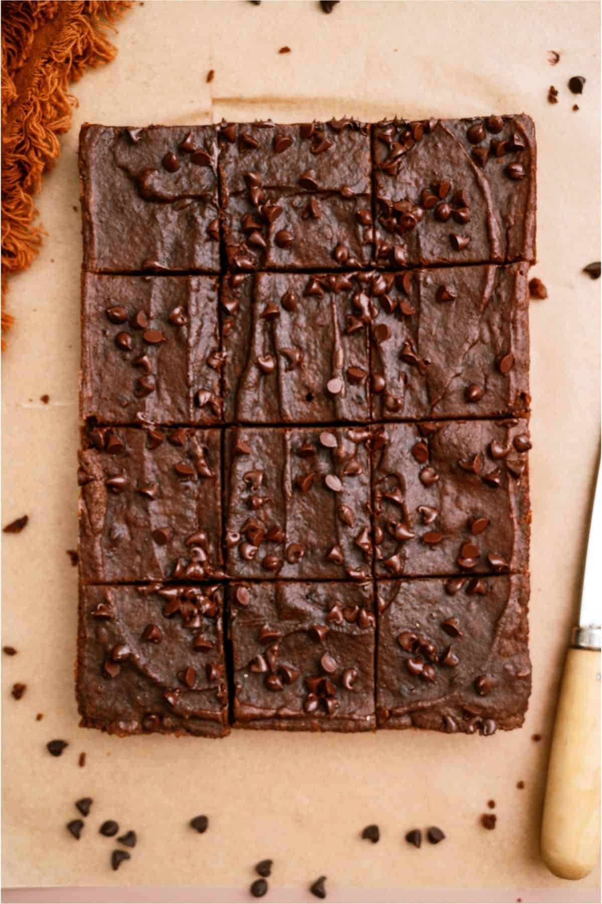 2 Ingredient Pumpkin Brownies cut into squares on parchment paper.