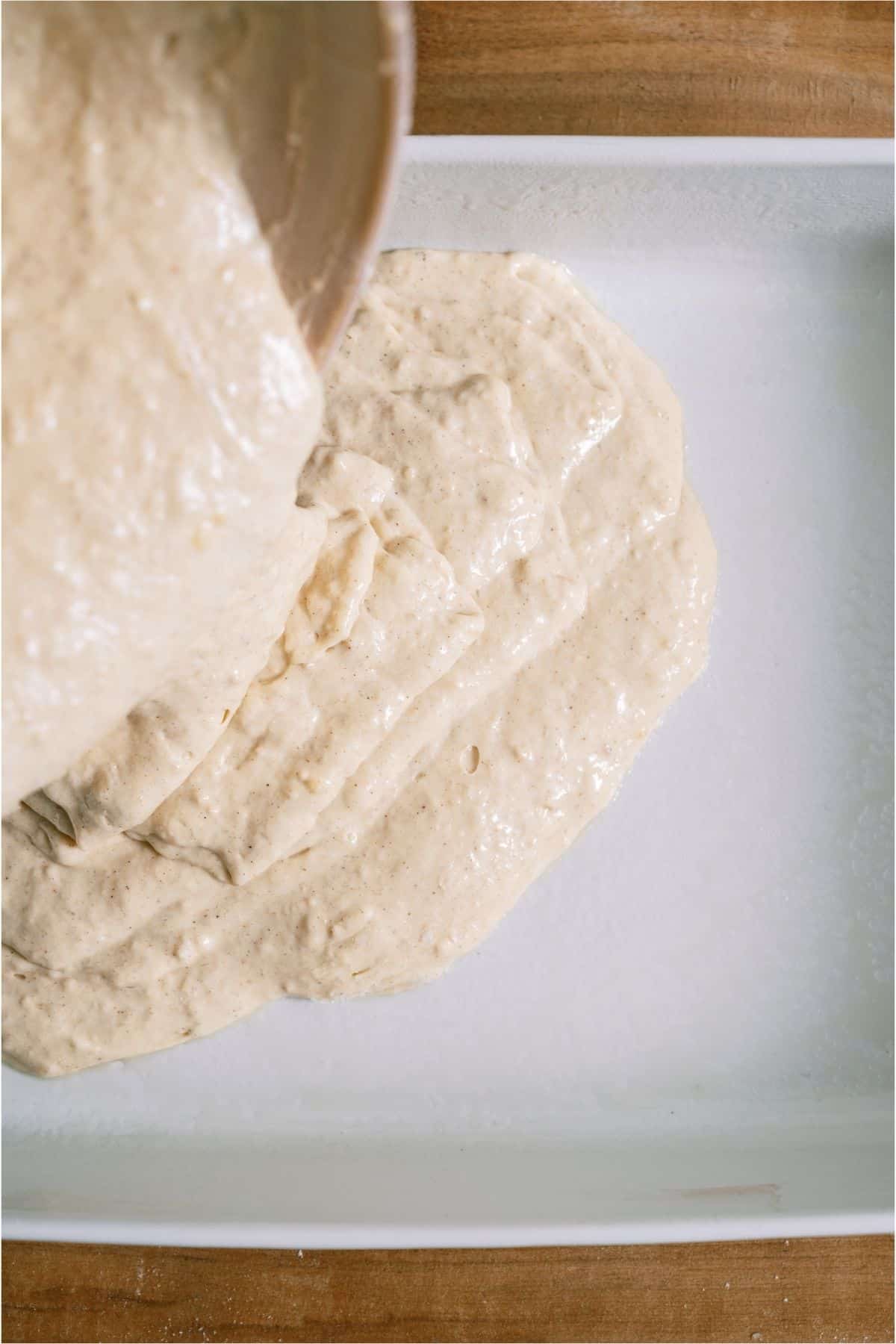 Pouring Baked Pancake batter into a baking dish.