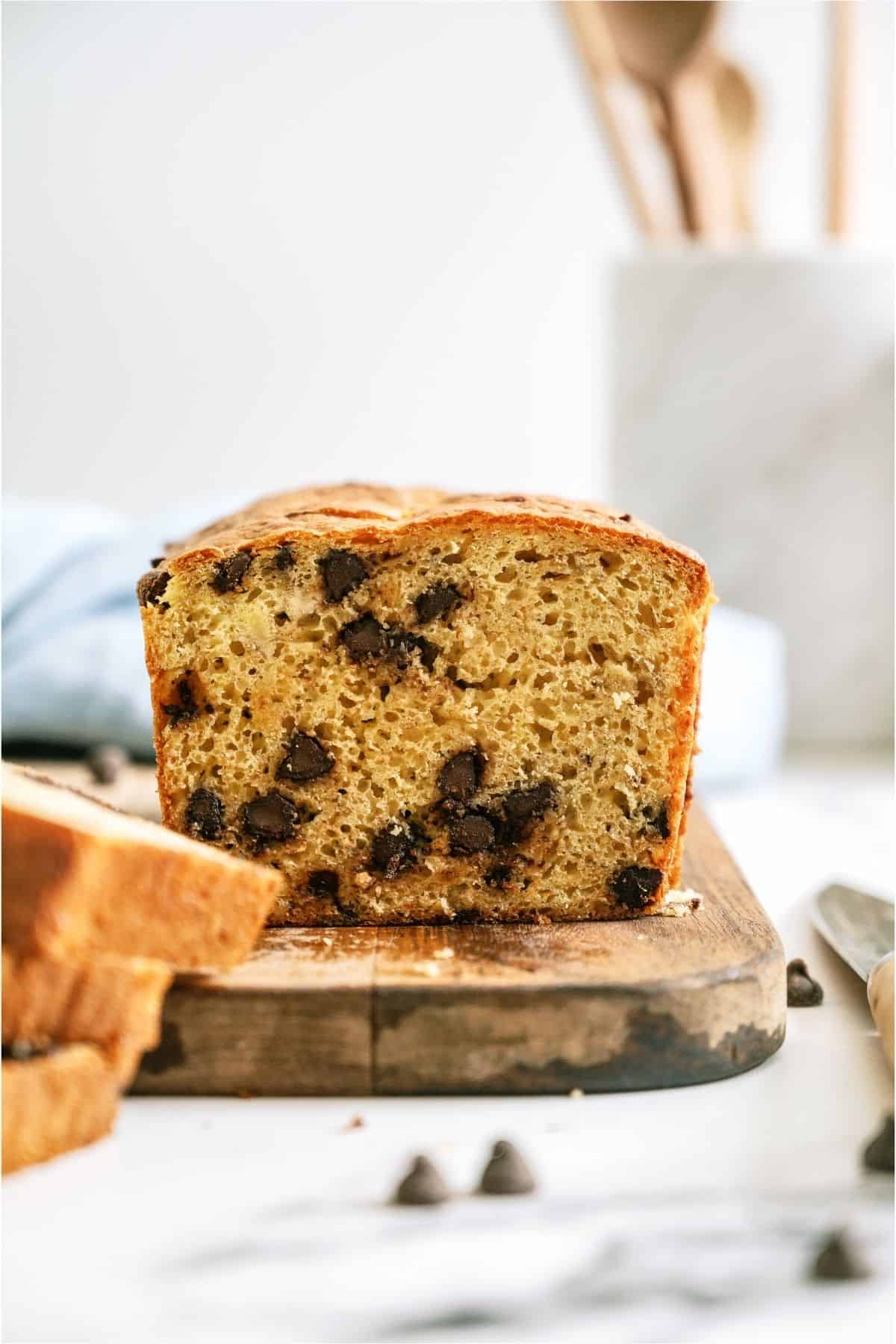 A loaf of banana bread sliced on a cutting board .