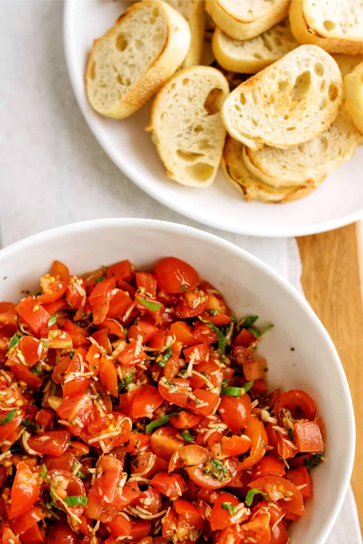 Fresh Classic Bruschetta in a bowl with sliced bread on the side