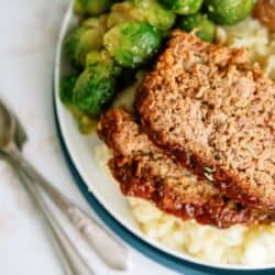 Homemade meatloaf served with Brussels sprouts and mashed potatoes.