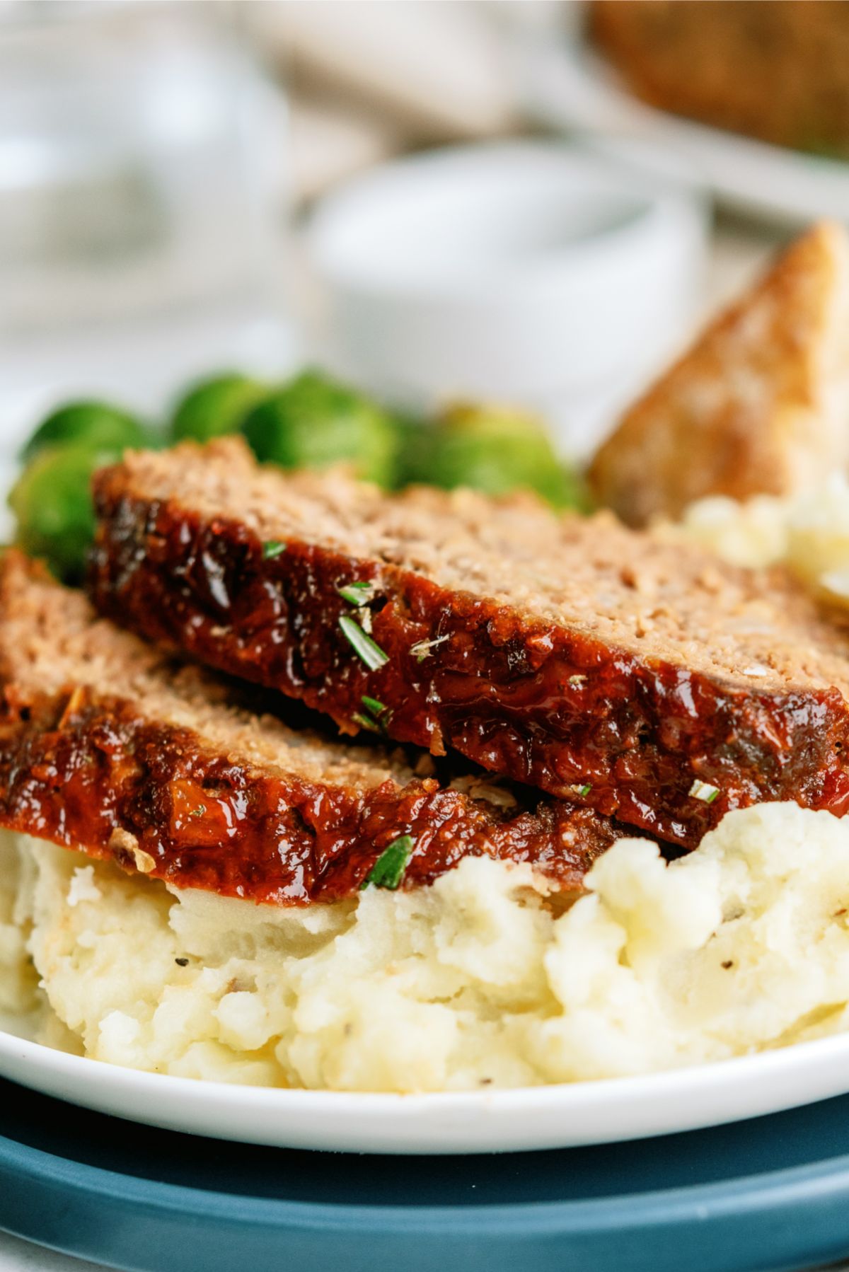 Close up of Grandma A’s Meatloaf sliced on a plate with mashed potatoes