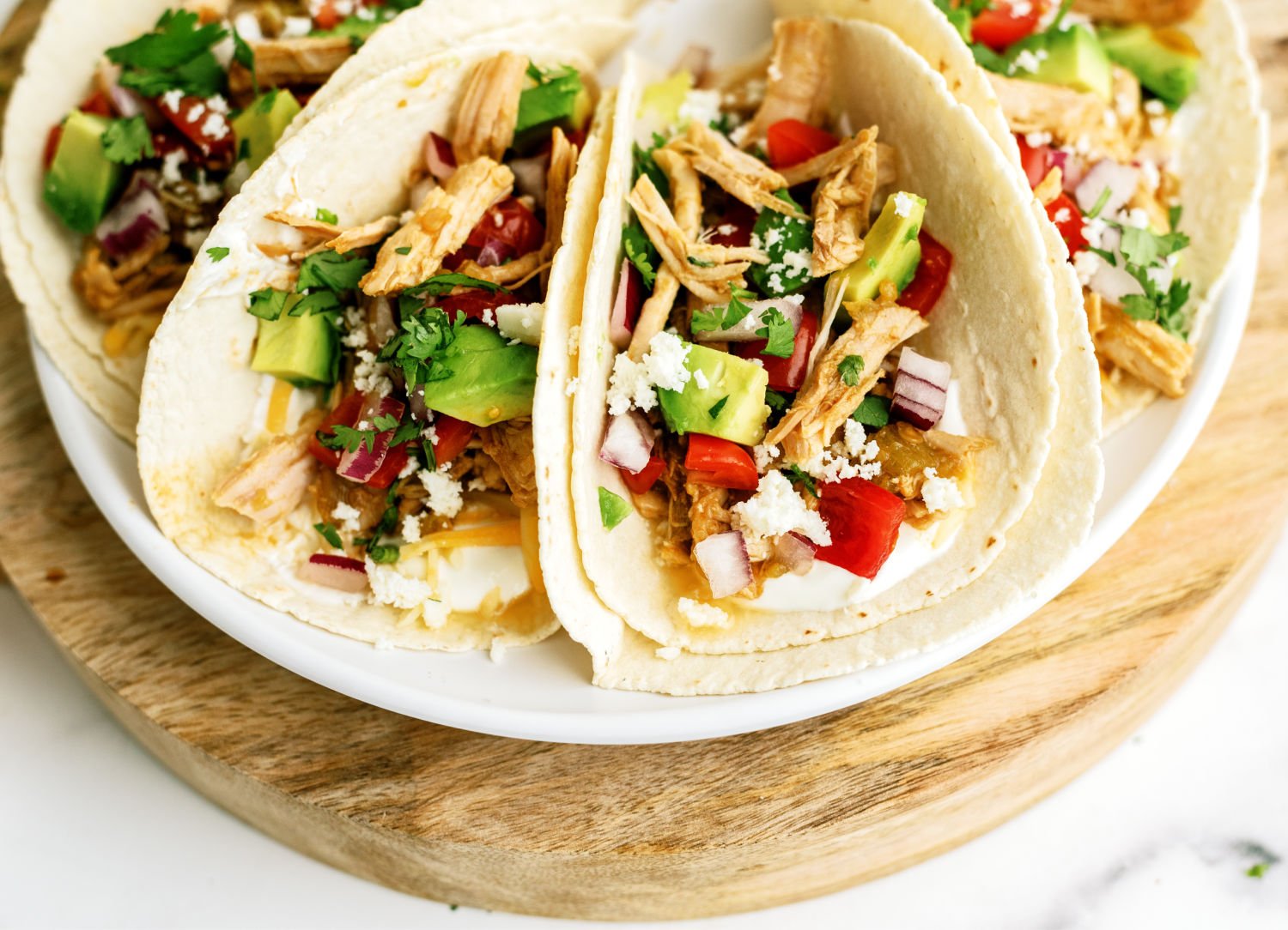 Slow Cooker Green Chile Pork Tacos on a plate with toppings