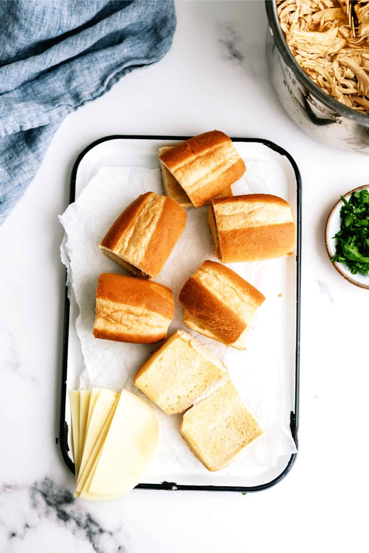 Hoagie rolls with sliced cheese on a cutting board