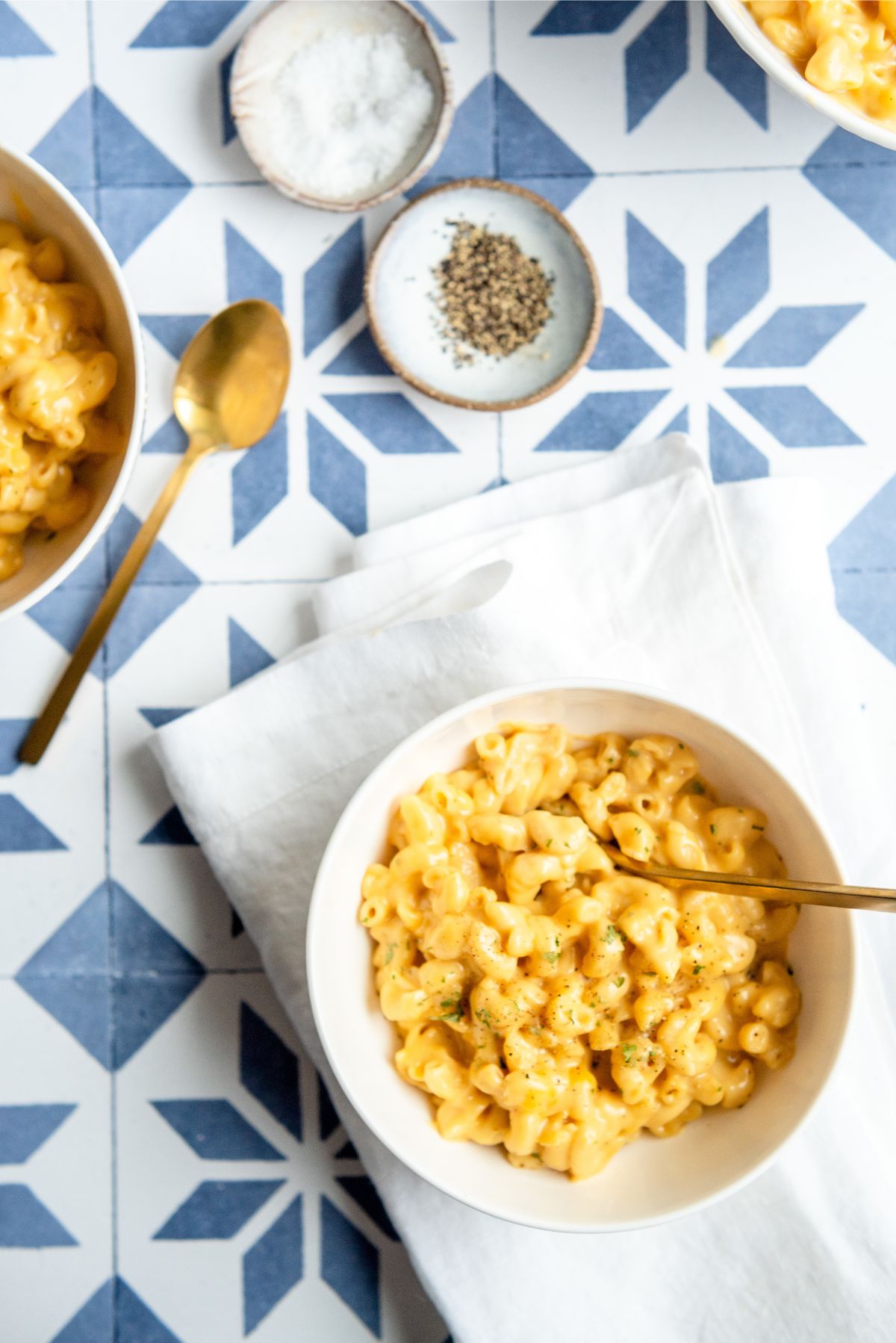 A serving of Instant Pot Easy Mac and Cheese in a bowl with salt and pepper on the side