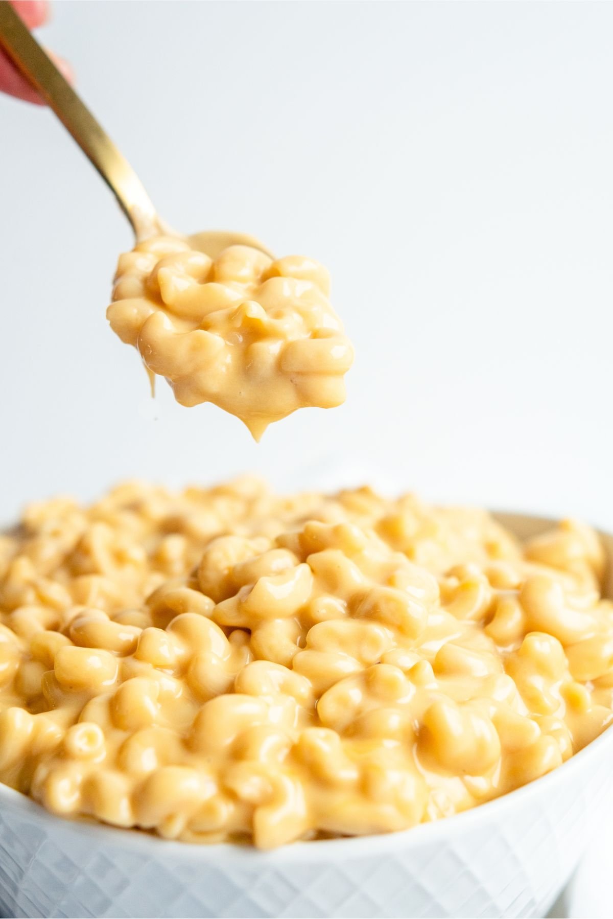 Spoonful of Instant Pot Easy Mac and Cheese over a bowl of Instant Pot Easy Mac and Cheese