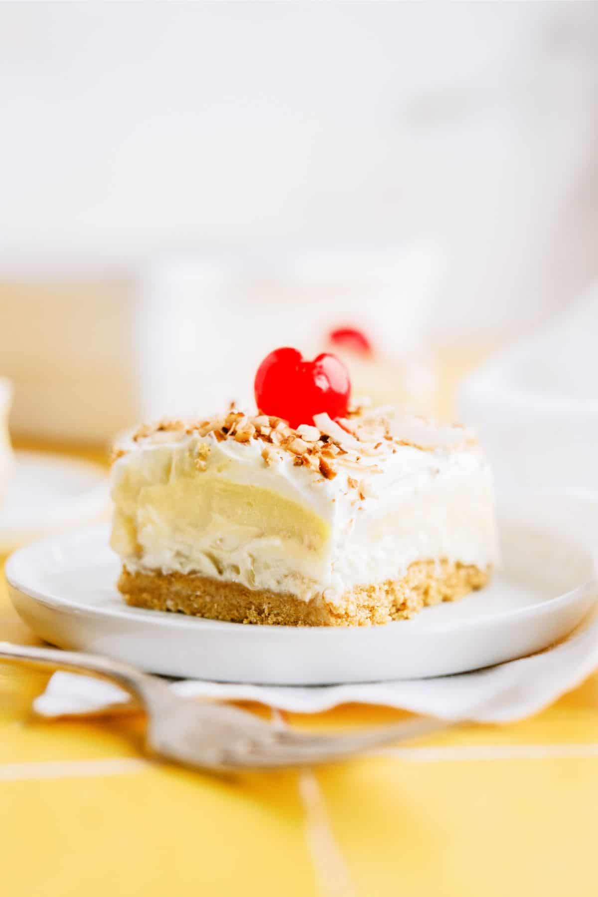 A square of Layered Pina Colada Dessert on a plate