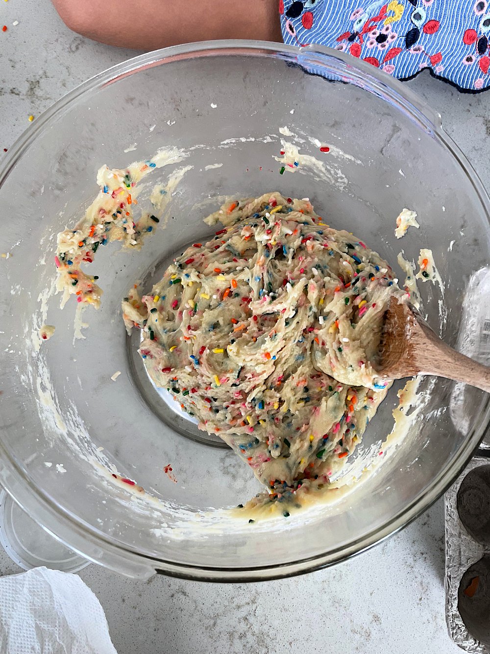 Funfetti Cake Batter Cookie dough batter in a glass bowl with a wooden spoon