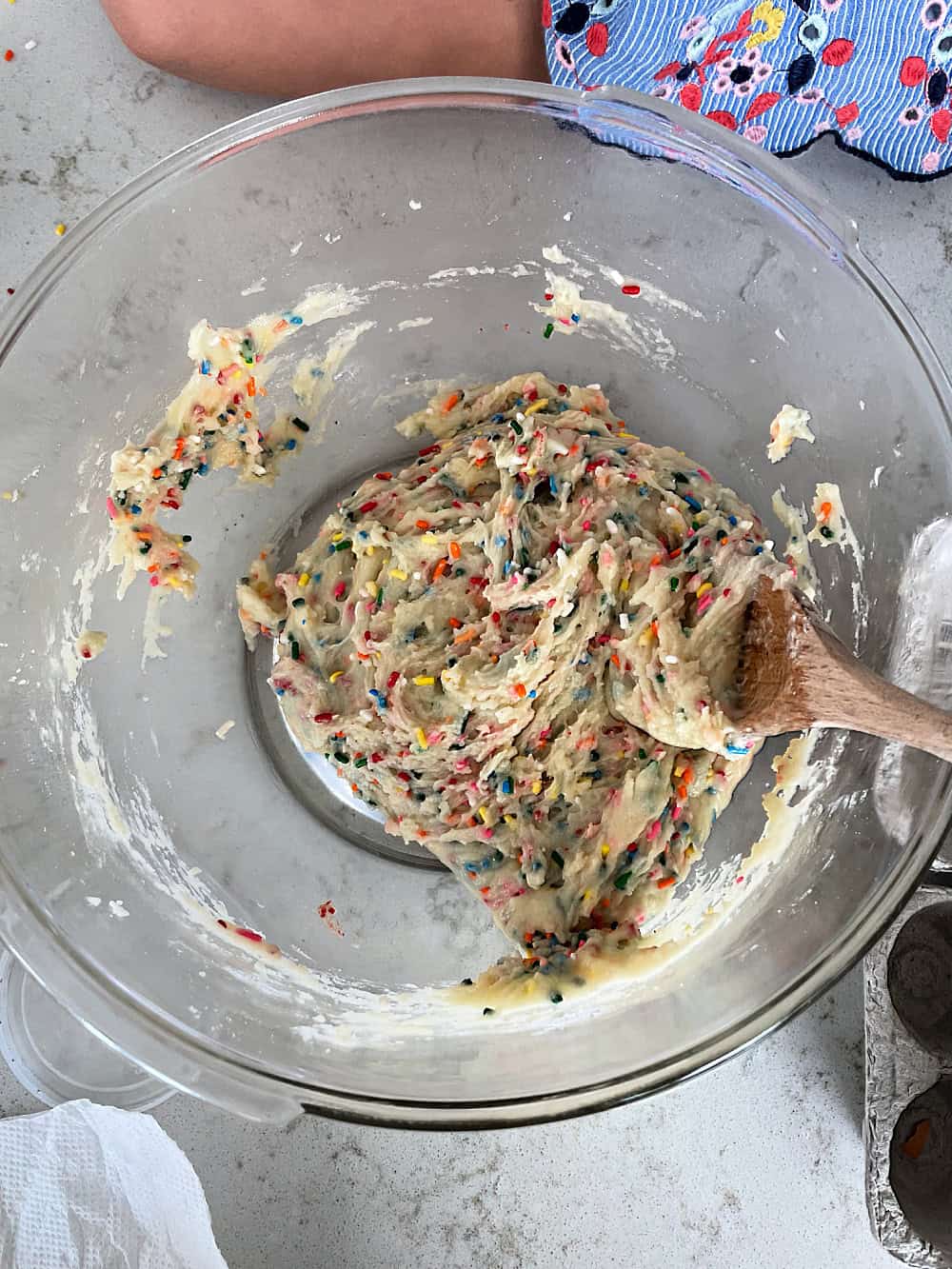 Mixing Funfetti Cake Batter Cookie dough in a glass mixing bowl.