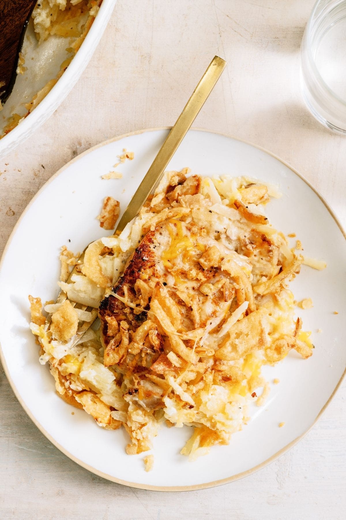 A serving of Pork Chop Casserole With Hashbrowns on a plate with a fork.