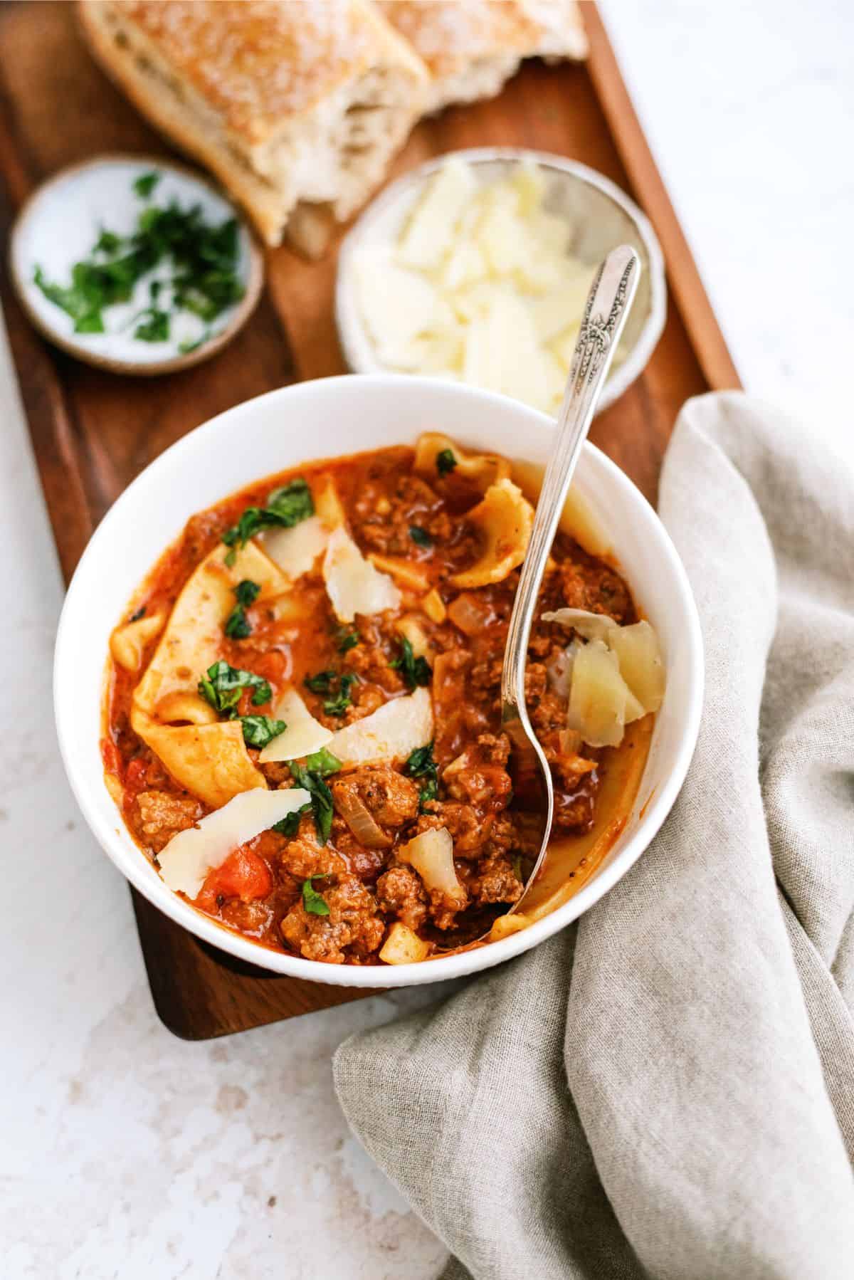 A bowl of Slow Cooker Beef Lasagna Soup with a side of bread