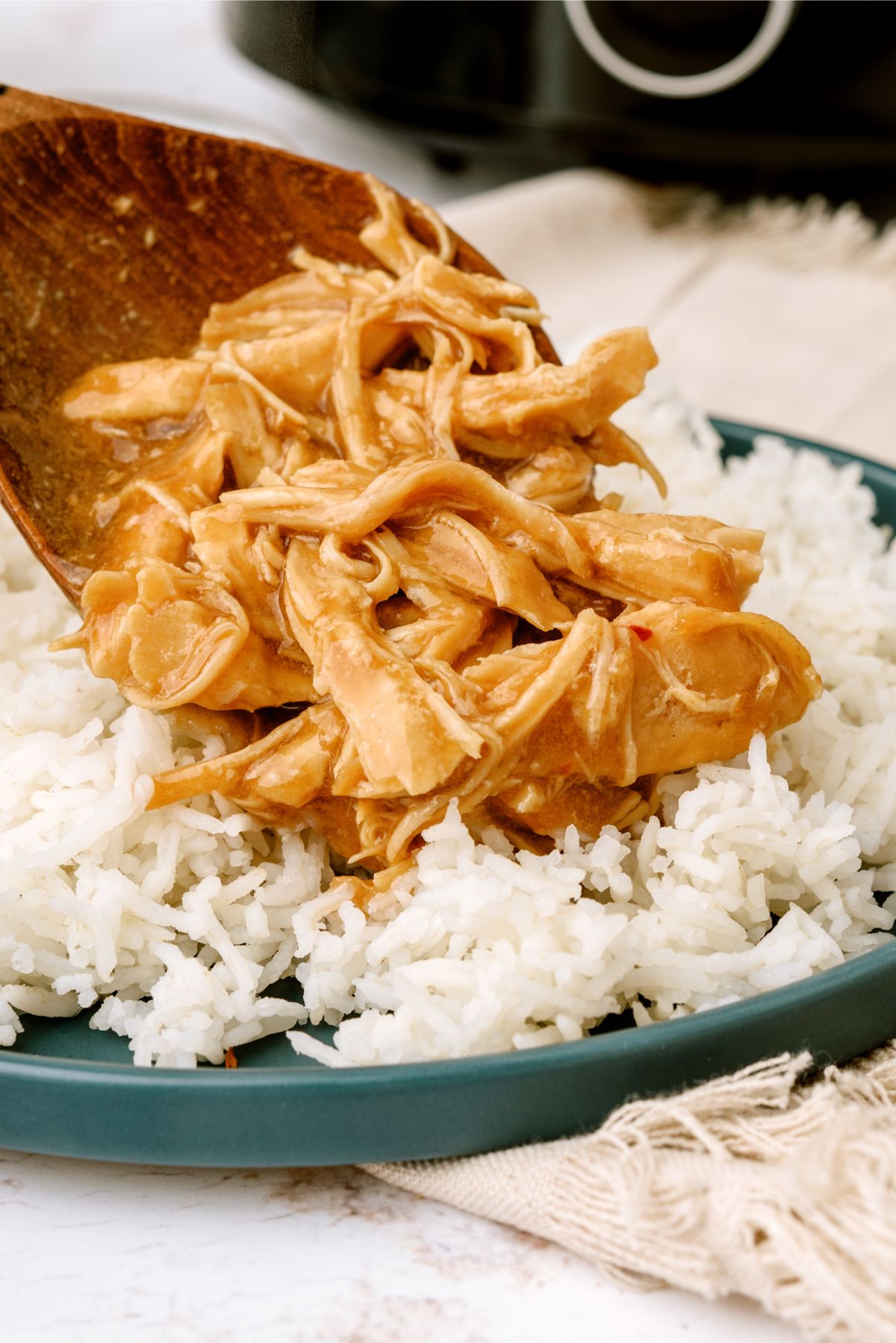 A spoonful of Slow Cooker Bourbon Chicken on top of a plate of rice