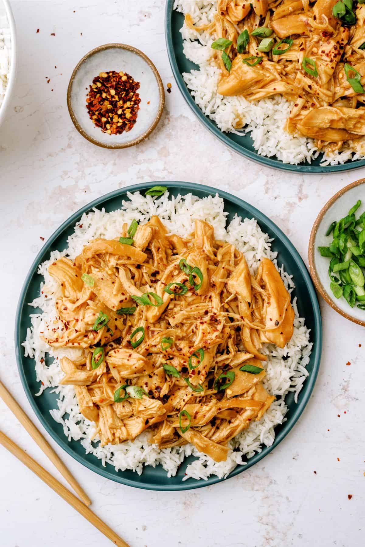 2 plates of Slow Cooker Bourbon Chicken on top of rice