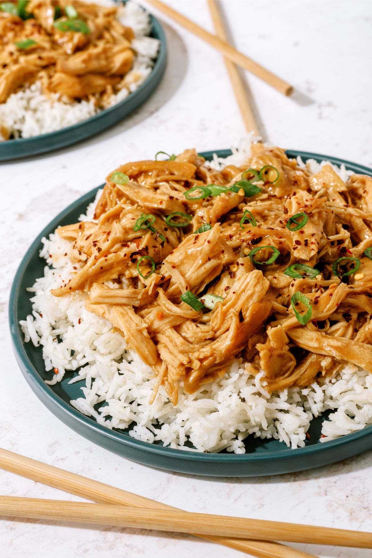 Side view of Slow Cooker Bourbon Chicken on top of a plate of rice