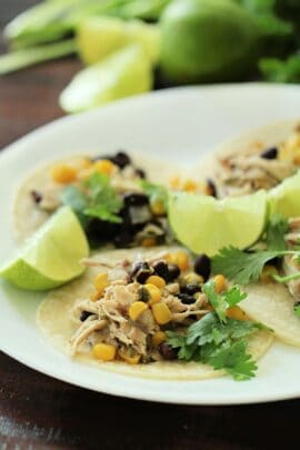 slow cooker cilantro lime chicken on a plate with limes