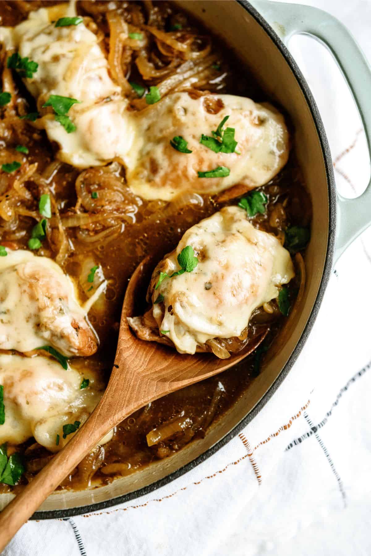 Wooden spoon in a pan of Slow Cooker French Onion Chicken