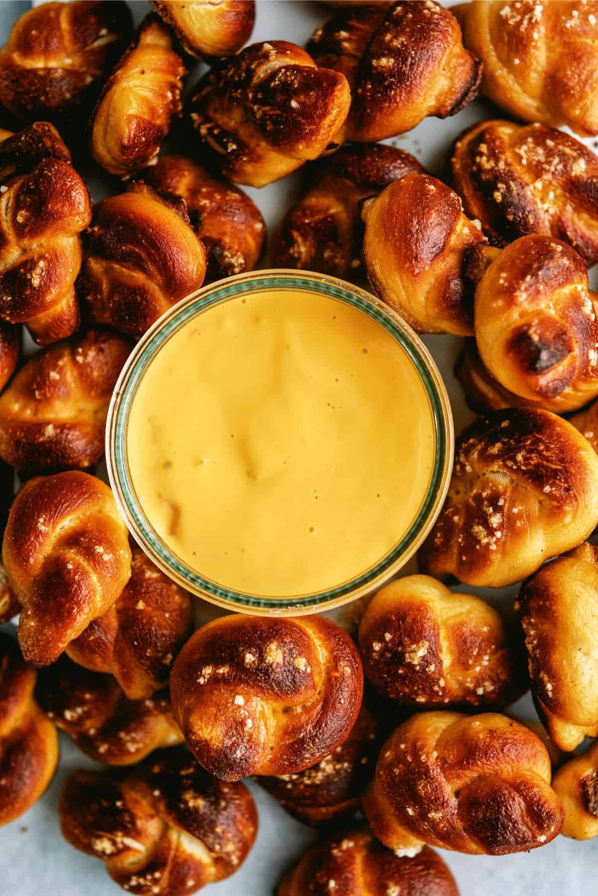 Twisted Soft Pretzel Bites Recipe surrounding a small dish of queso