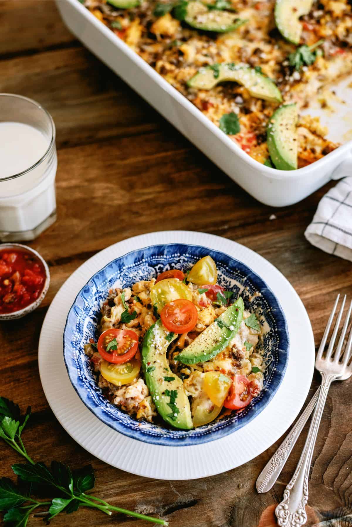 A serving of Breakfast Burrito Casserole on a plate with toppings