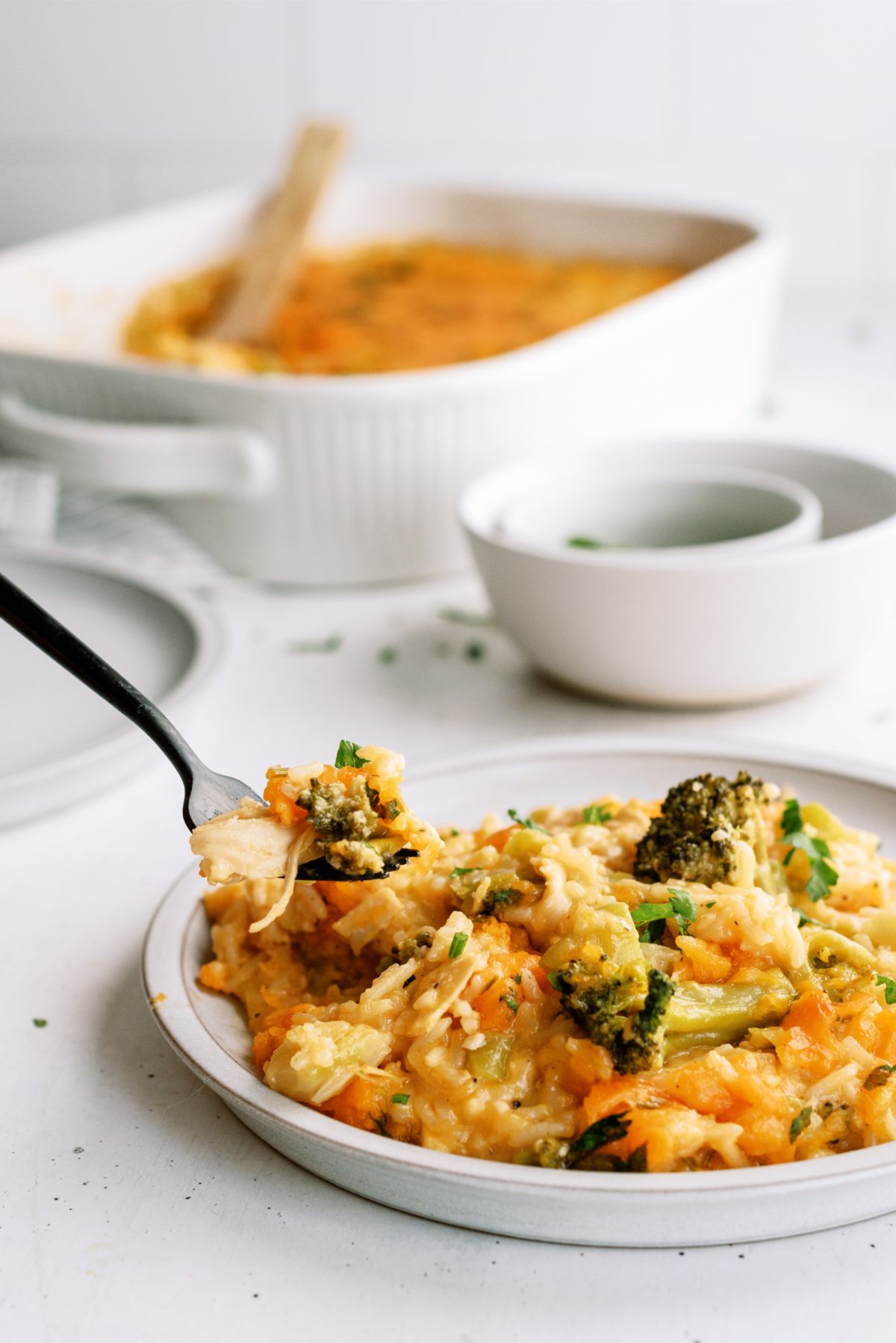 A serving of Cheesy Chicken Broccoli Rice Casserole Recipe (No Soup) on a  plate with a fork