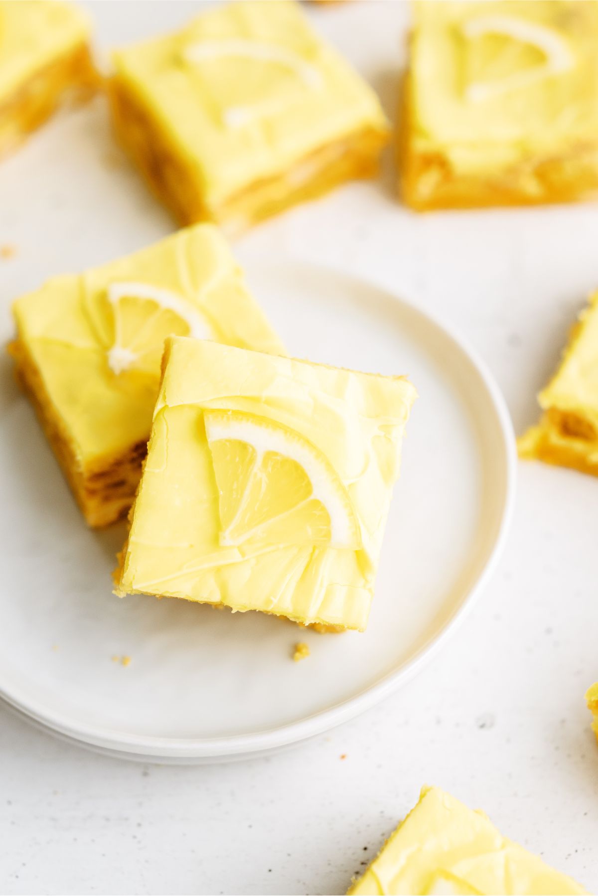 Lemon Cookie Cheesecake Bar on a plate topped with a lemon slice