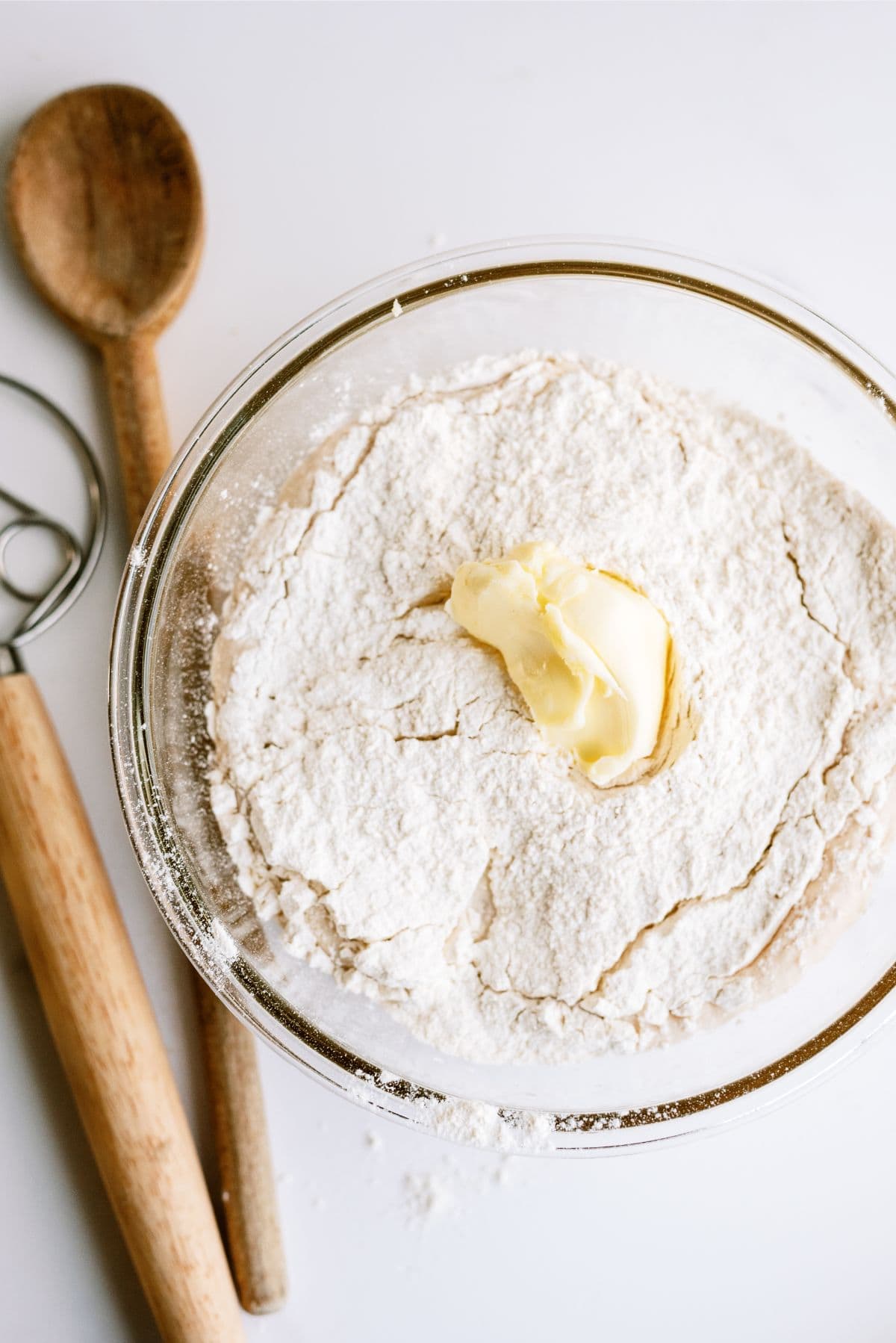 Dough ingredients combined in a mixing bowl with softened butter on top