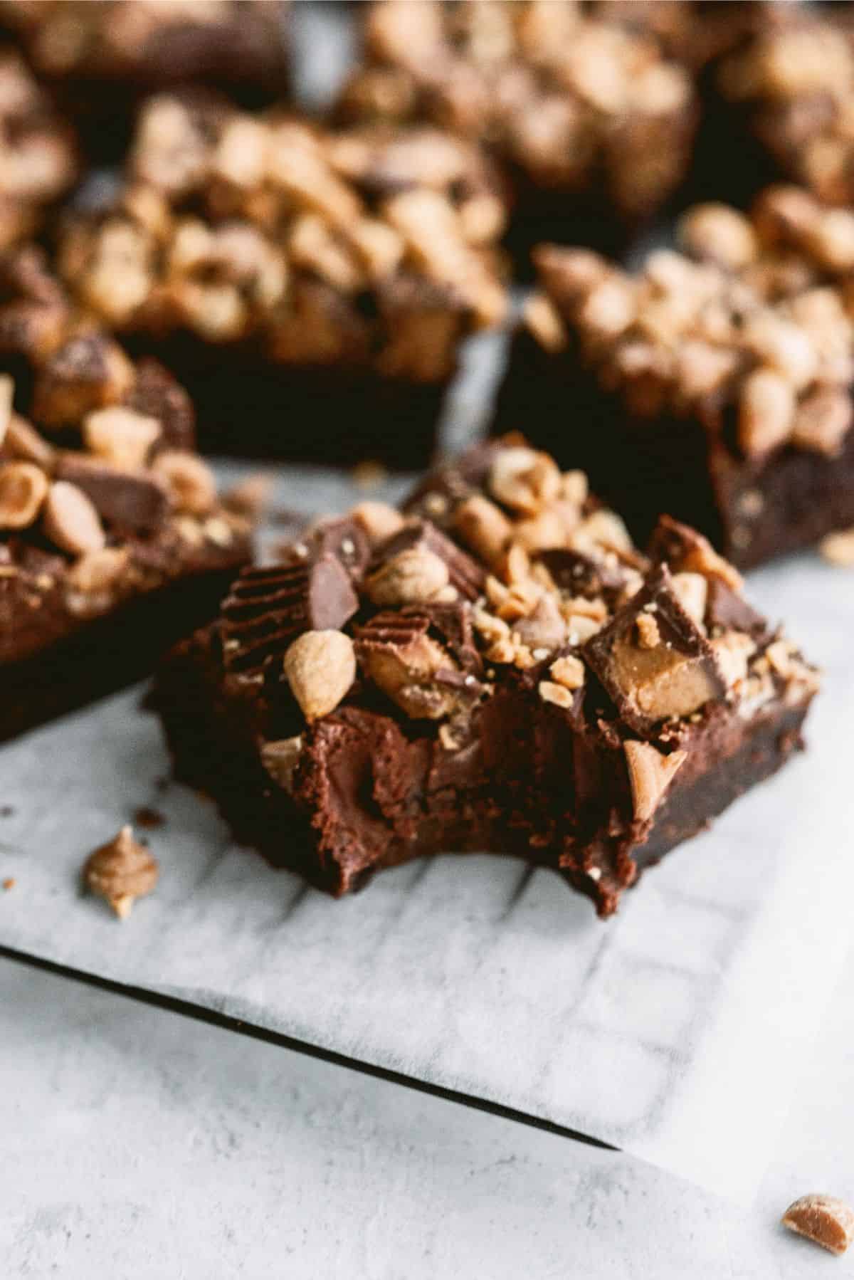 Squares of Reese’s Brownies on a cooling rack with one missing a bite