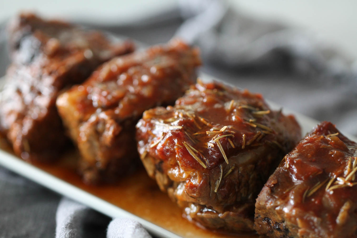 Side view of Instant Pot Glazed Short Ribs on a serving plate