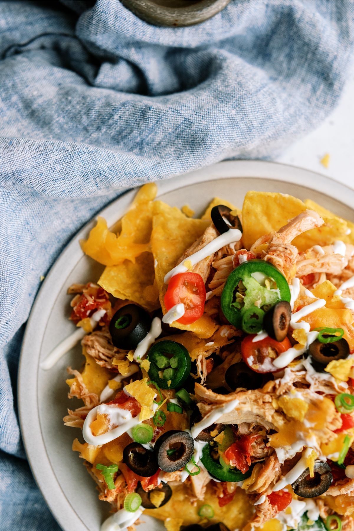 Top view of Slow Cooker Shredded Chicken Nachos on a plate with toppings
