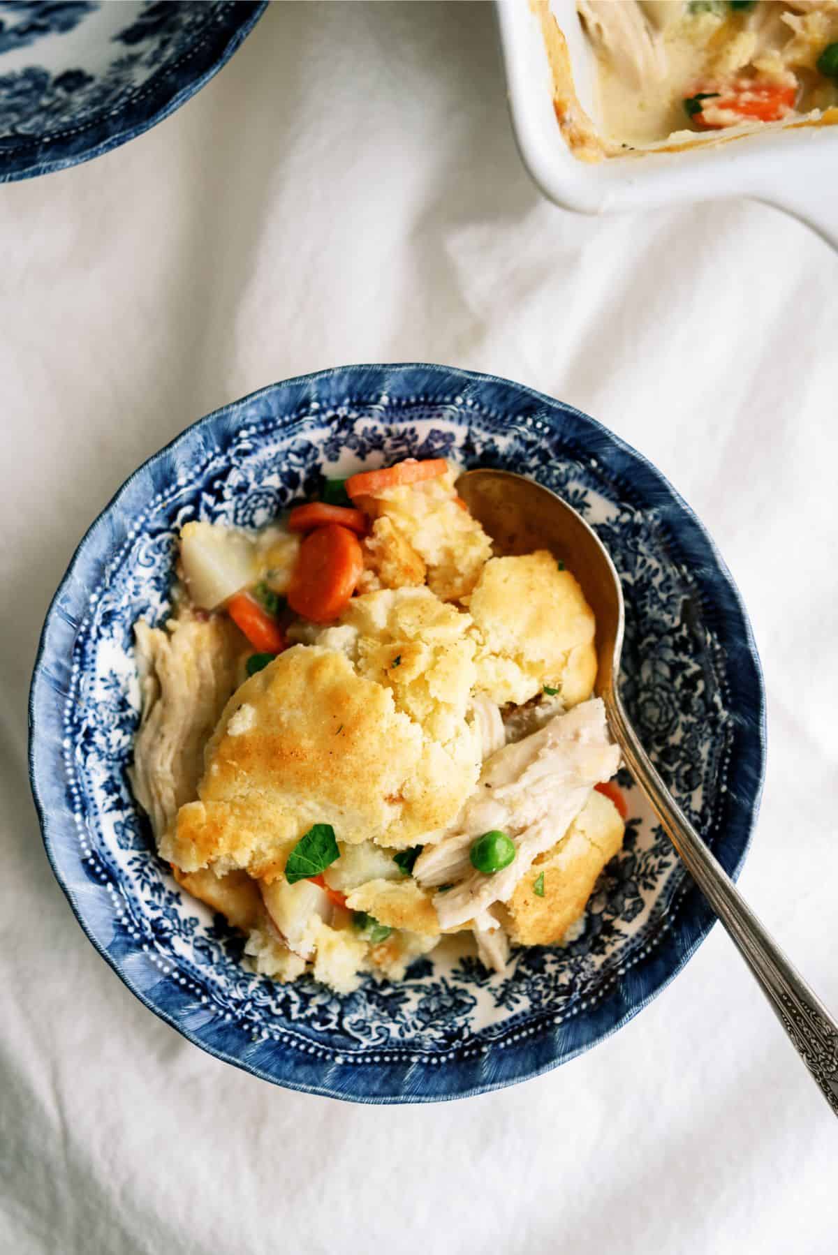 A serving of Cheesy Chicken Pot Pie in a bowl with a spoon