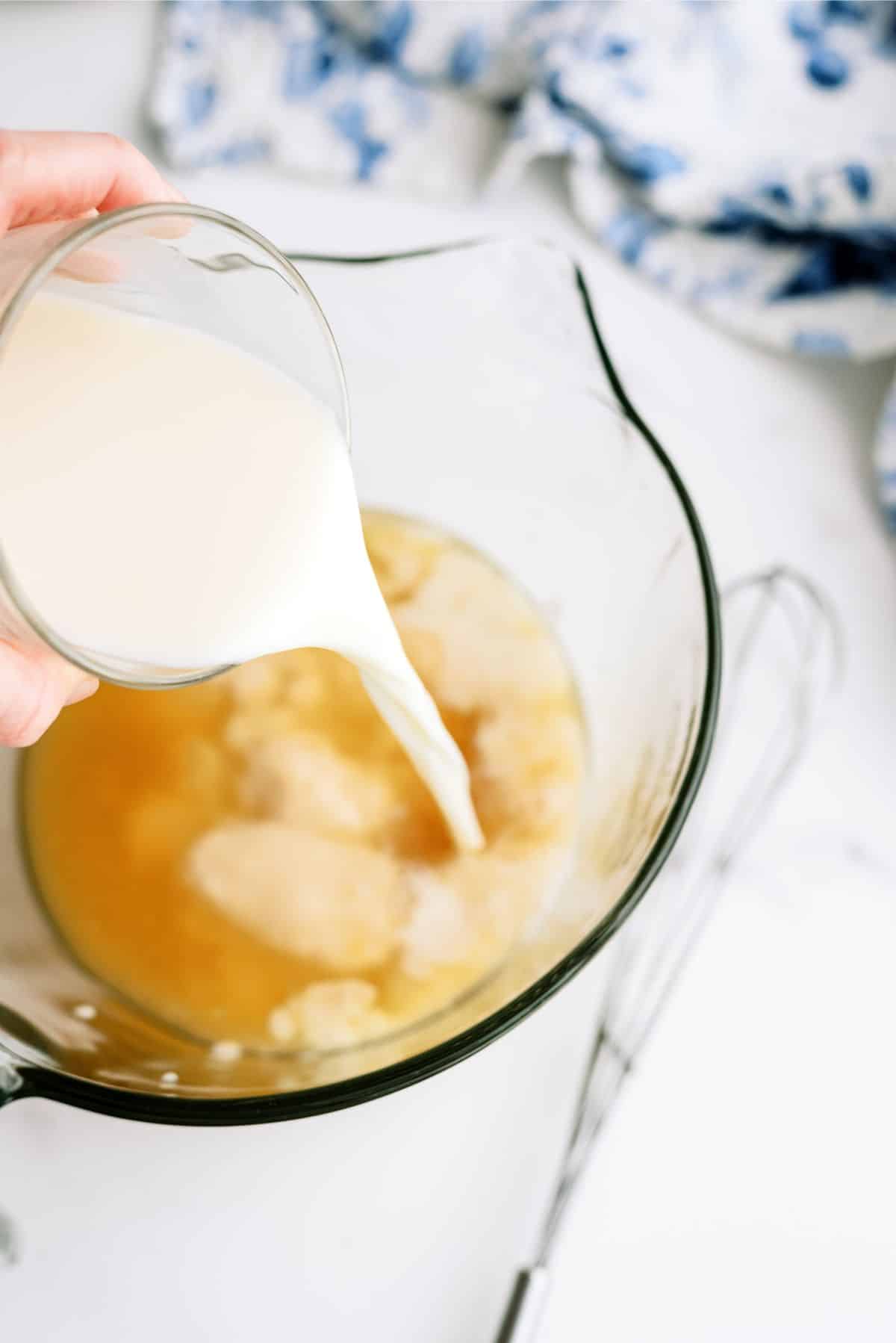 Mixing together cheesy sauce ingredients in bowl