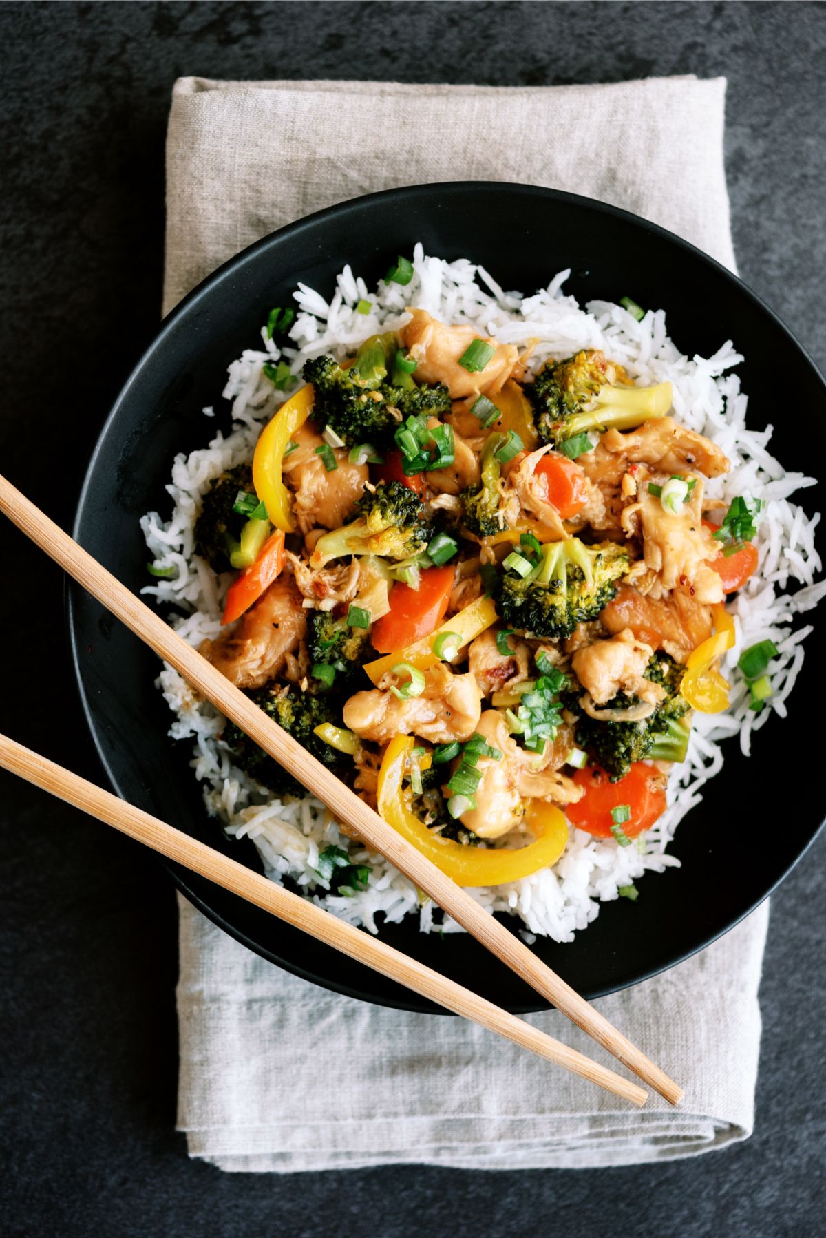 Top view of Instant Pot Chicken and Veggie Stir Fry served over rice with chopsticks