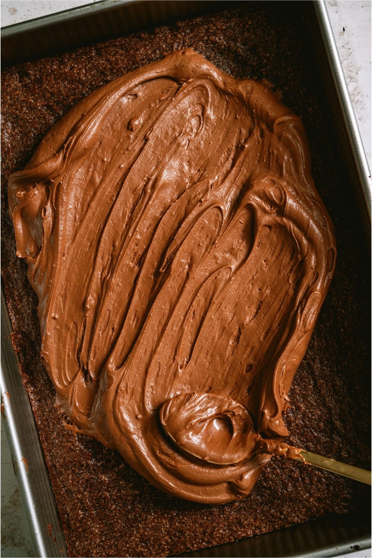 Frosting on top of a pan of brownies.