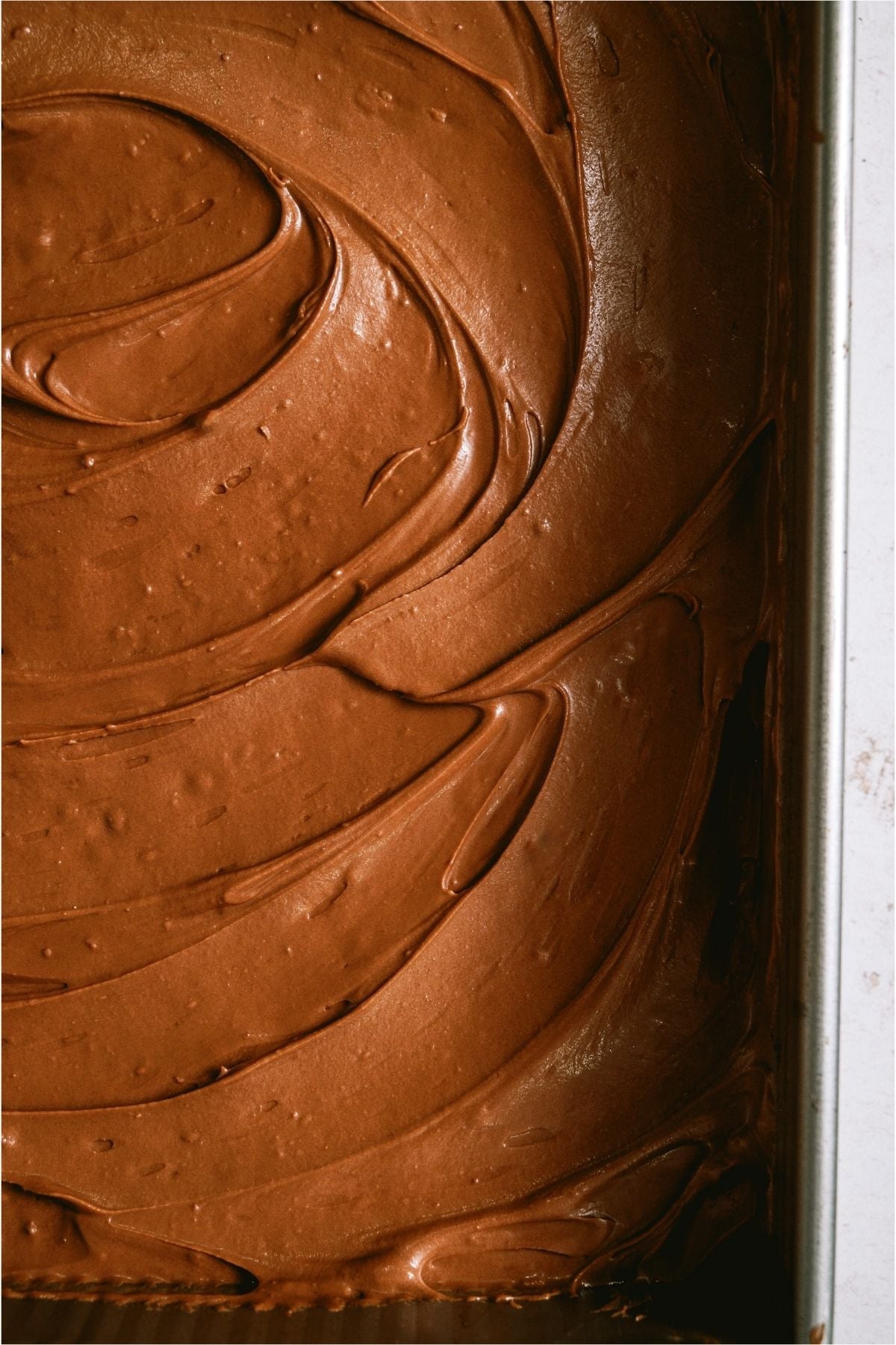 Lunch Lady Brownies topped with frosting in a pan.
