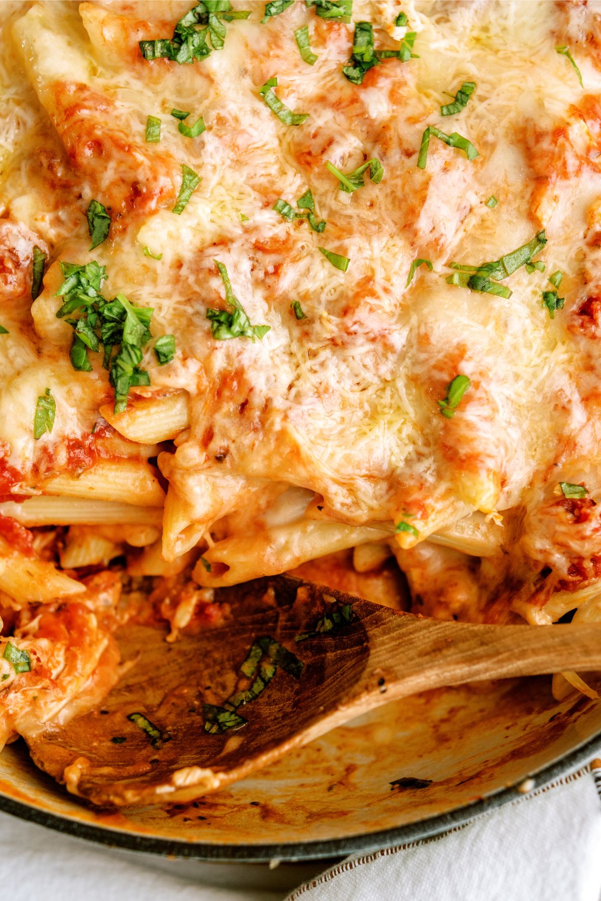 Top view of Pink Sauce Chicken Pasta Bake in a baking dish with a serving spoon
