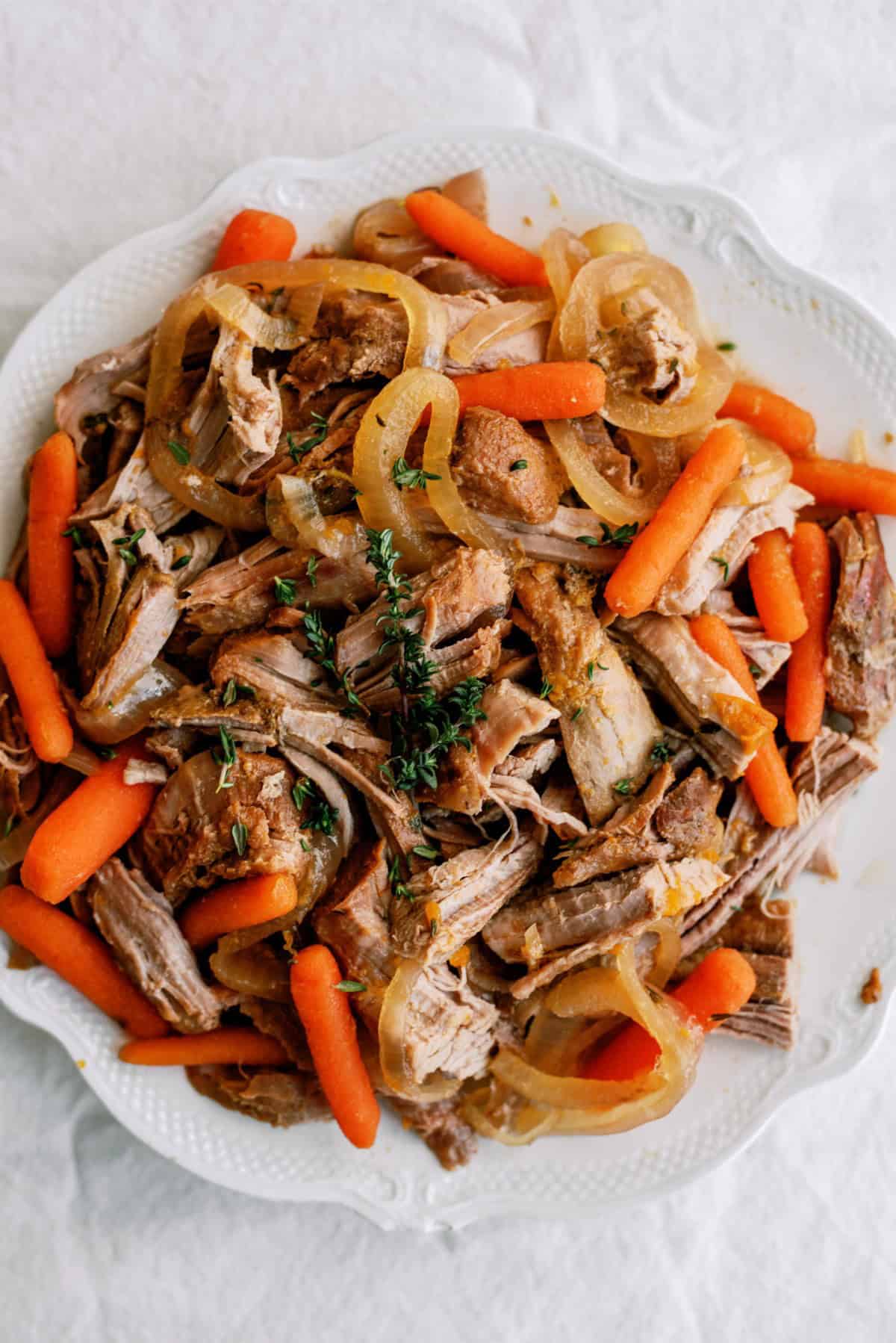 Slow Cooker Apricot Glazed Pork shredded on a serving plate