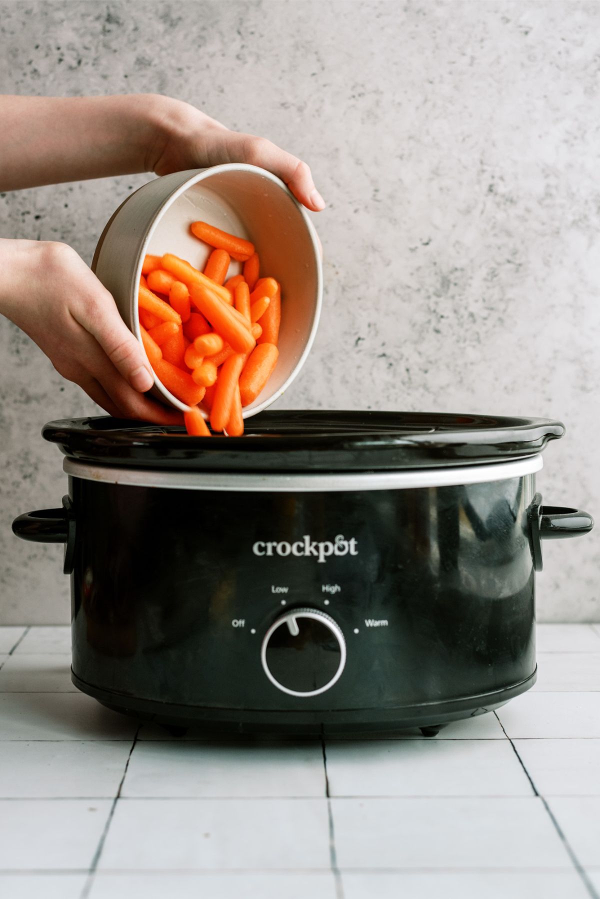 Dumping baby carrots into the slow cooker