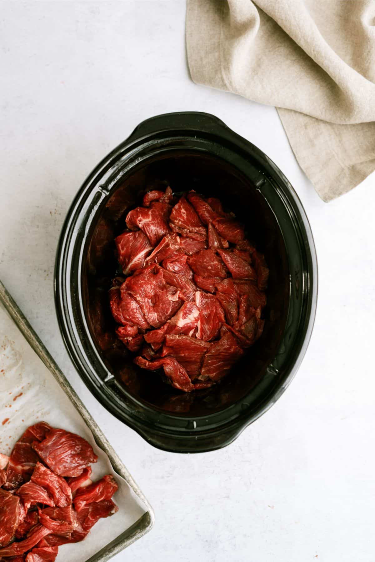 Raw steak strips in slow cooker