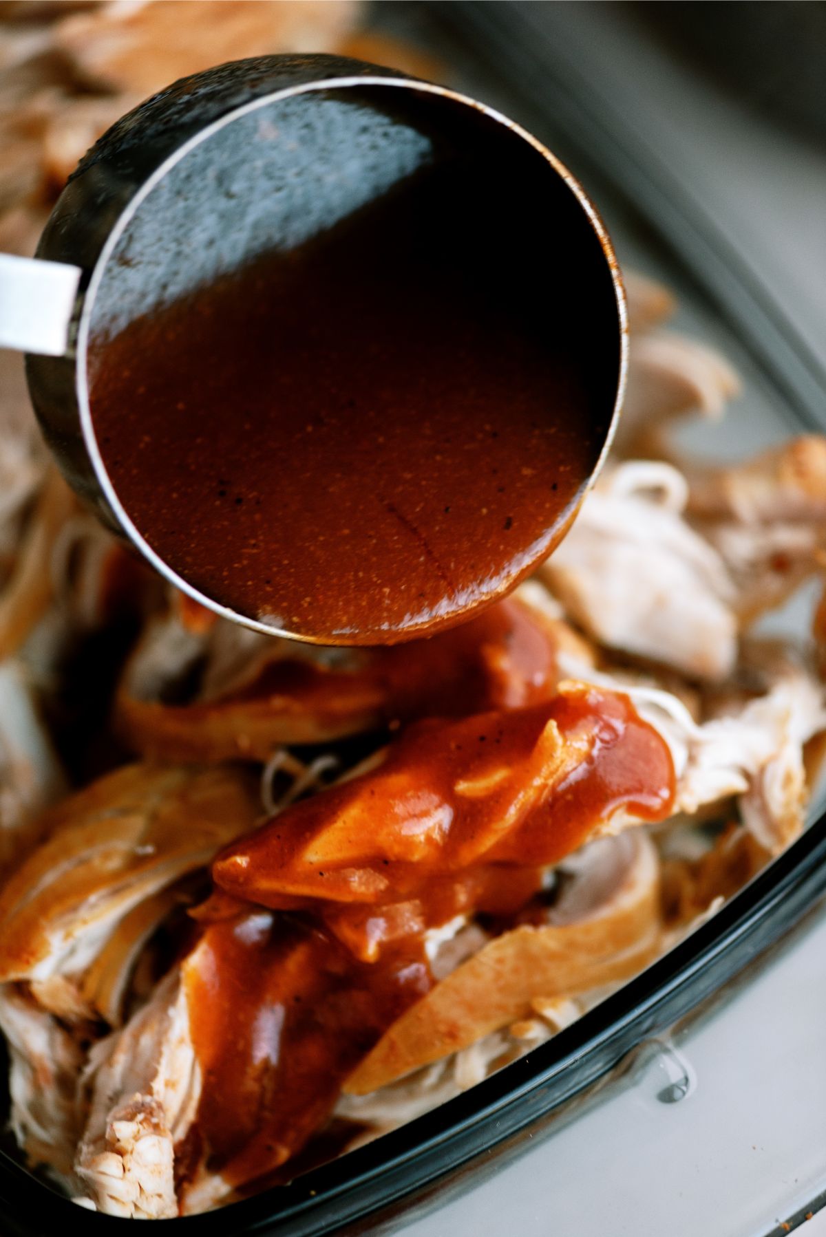 Pouring sauce on top of chicken