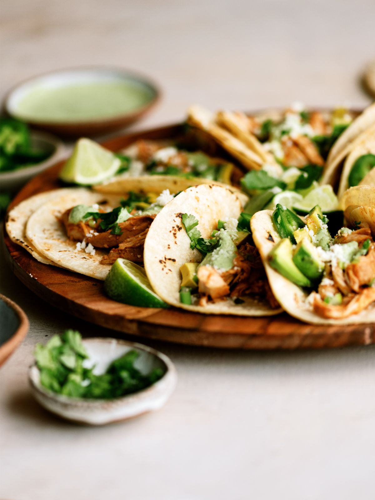 Close up view of Slow Cooker Chicken Tinga Tacos with sauce and toppings.