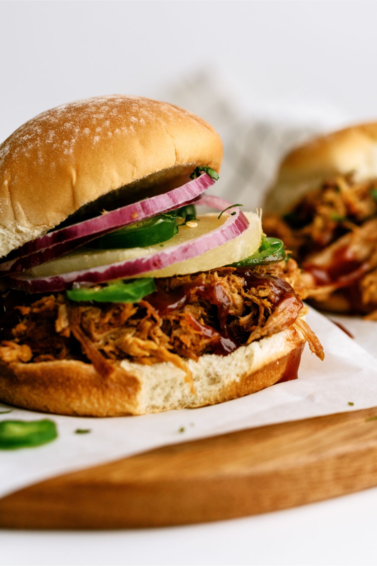 Slow Cooker Pineapple Pulled Pork Sandwich with toppings on a plate