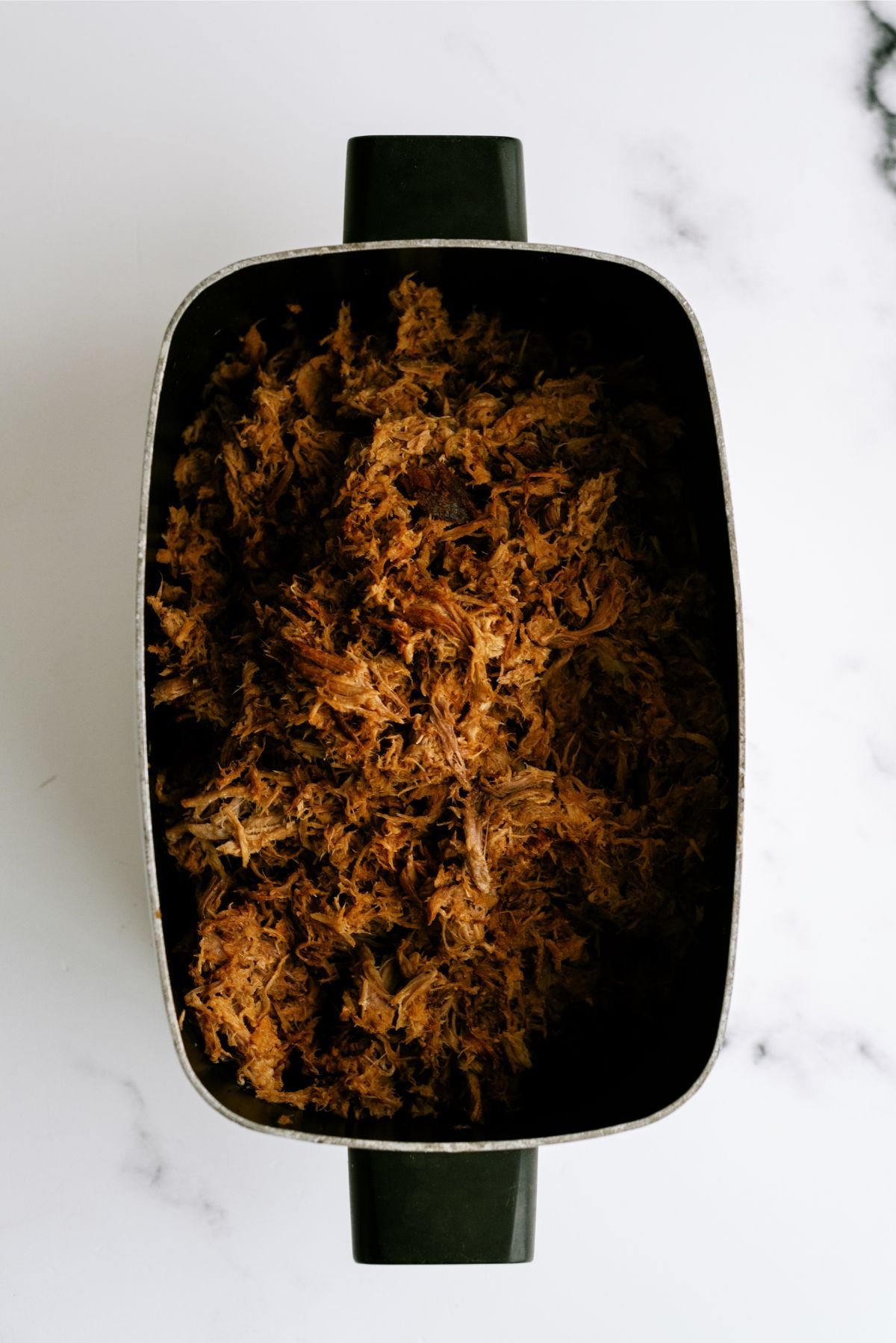 Slow cooker filled with shredded Slow Cooker Pineapple Pulled Pork