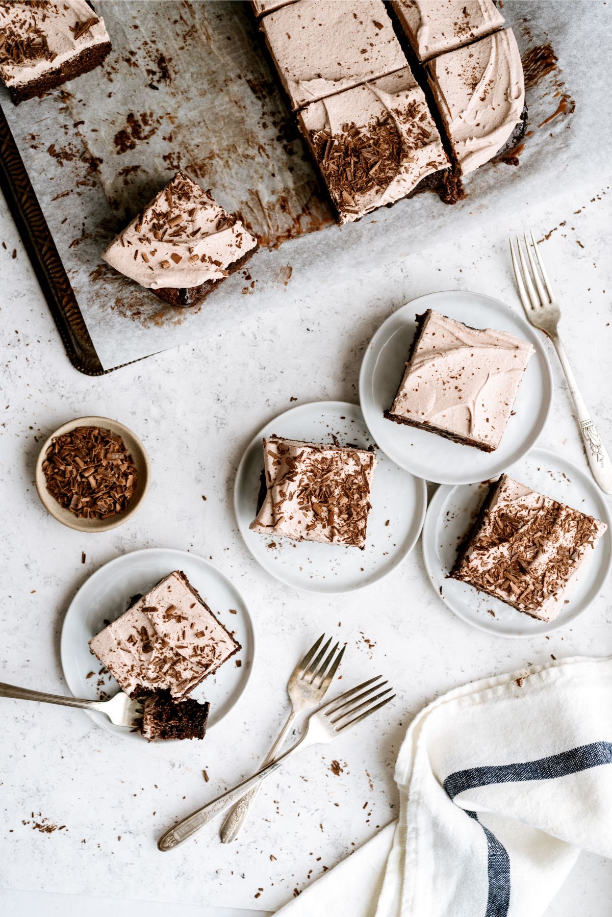 Hot Fudge Chocolate Poke Cake sliced into squares with 4 slices on plates