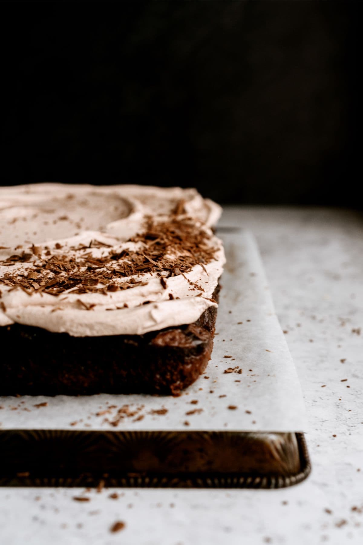 Close up of a corner of Hot Fudge Chocolate Poke Cake with shaved chocolate on top