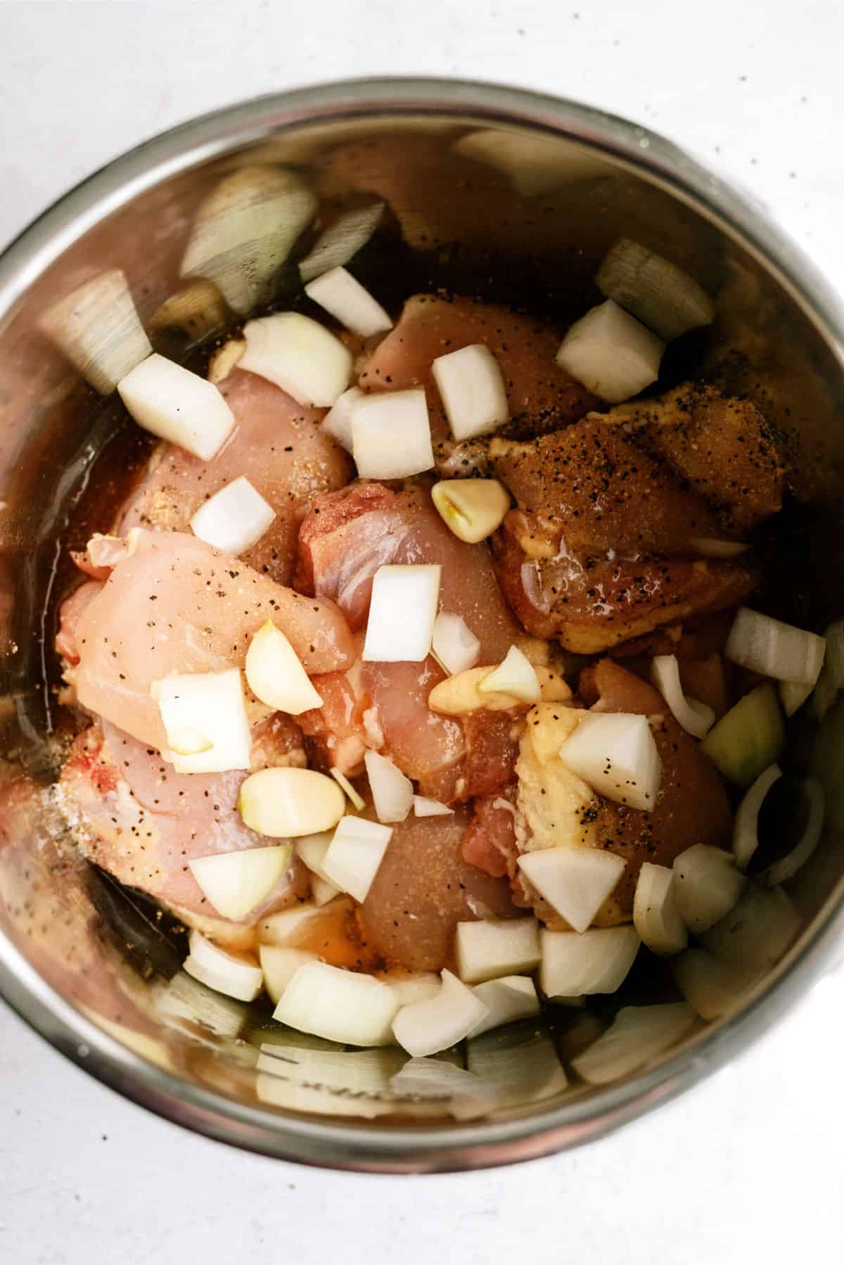 Chopped garlic added on top of chicken thighs in the Instant Pot