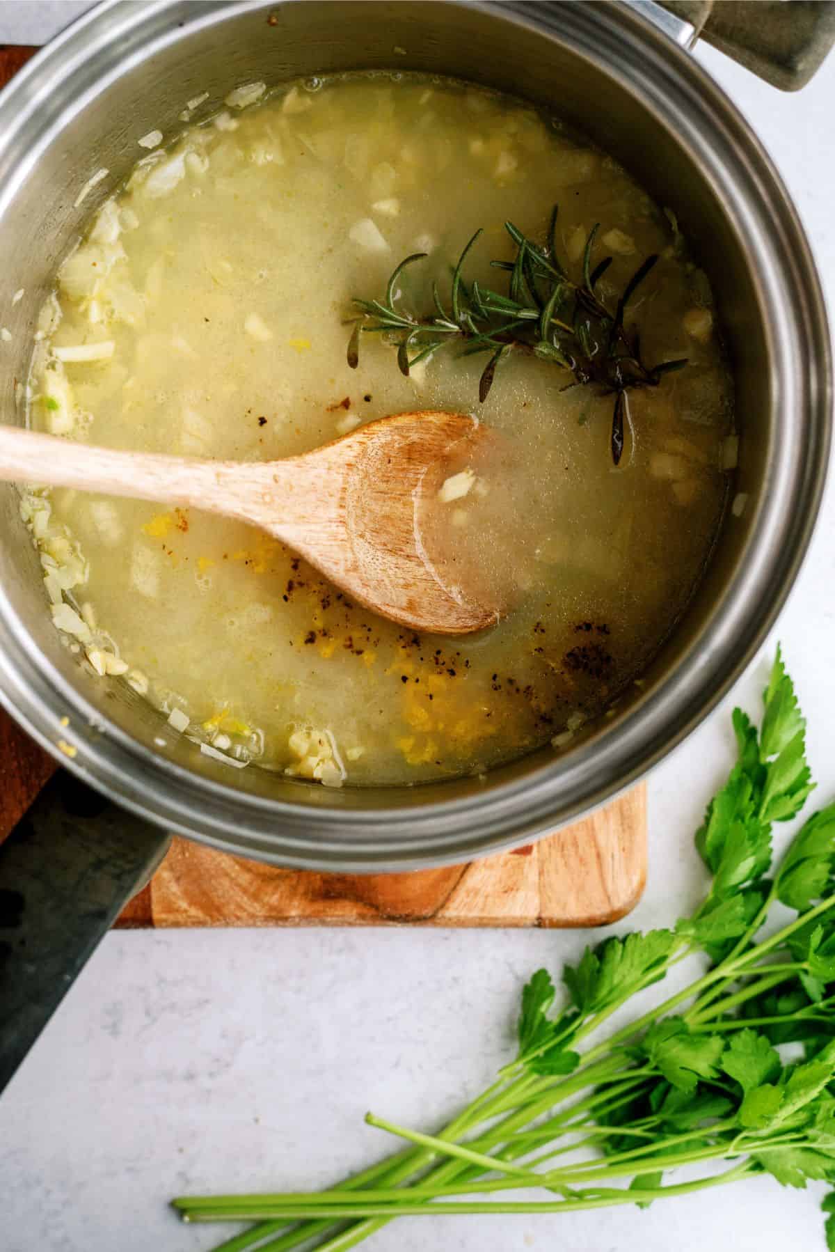 Ingredients for Lemon Glaze in sauce pan mixed with wooden spoon